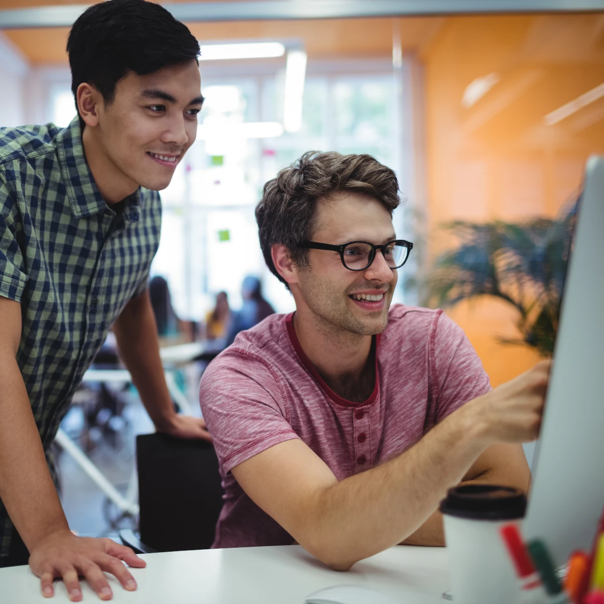Two men verifying information on a PC